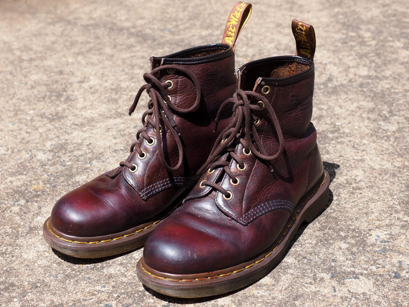 Pair of brown Dr Martens 1460 boots with yellow welt stitching