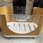 Beautiful Ubabub Pod Cot 2-1 convertible Bed with Junior Bed Conversion Kit in natural wood.