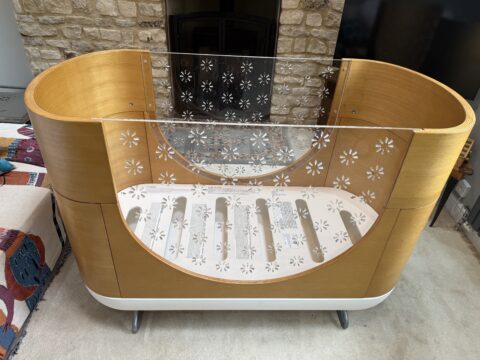 Beautiful Ubabub Pod Cot 2-1 convertible Bed with Junior Bed Conversion Kit in natural wood.